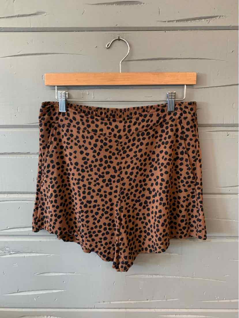 Beige high-waist shorts with black irregular dot pattern, lightweight fabric, relaxed fit.