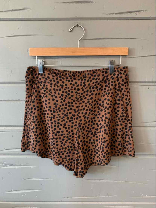 Beige high-waist shorts with black irregular dot pattern, lightweight fabric, relaxed fit.