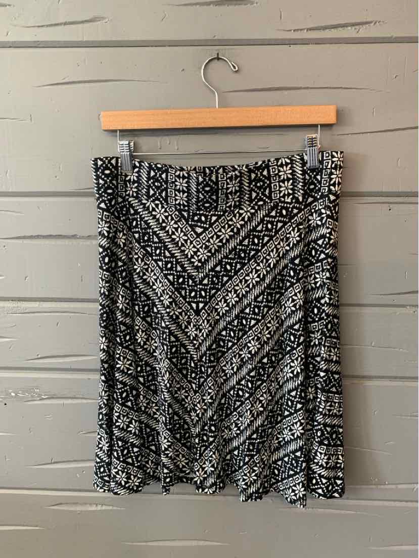 Black and white patterned knee-length skirt with geometric stripes and floral motifs on lightweight fabric.