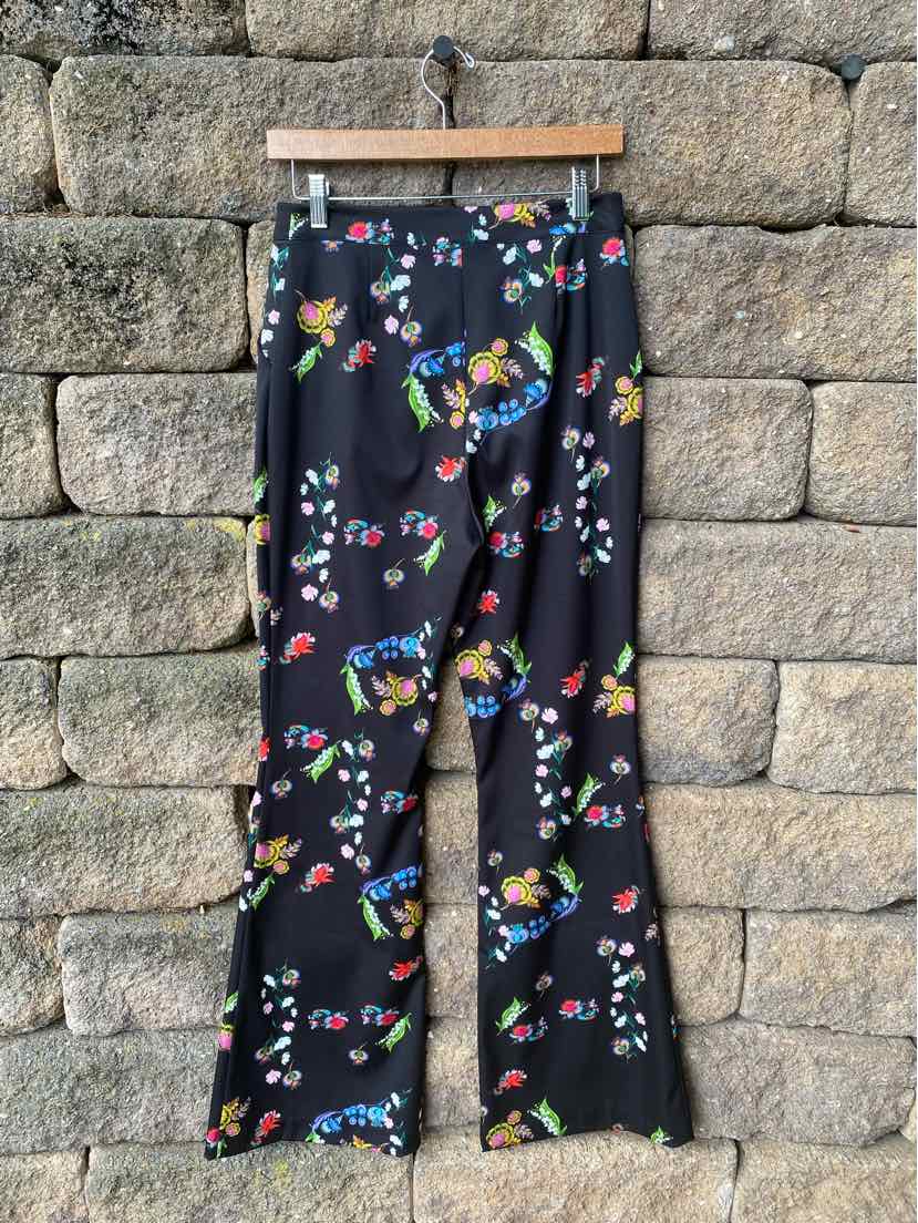 Black sleeveless jumpsuit with vibrant multicolor floral print and wide legs.