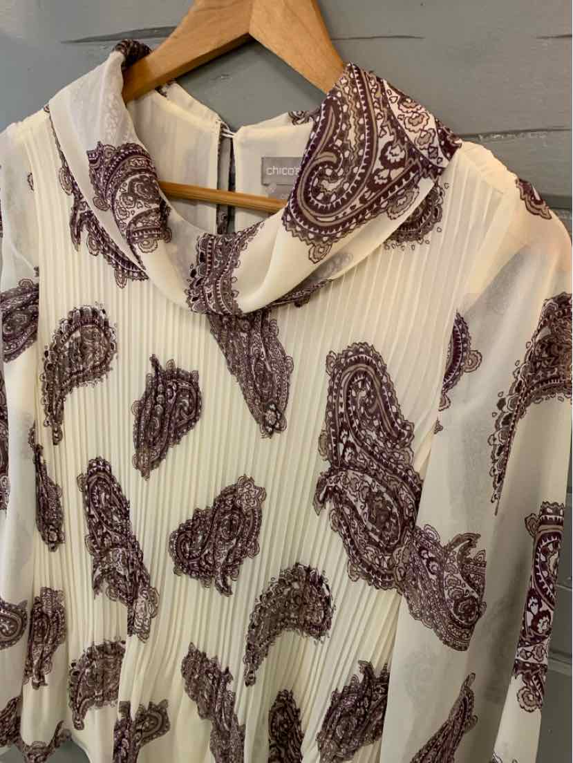 White blouse with maroon paisley print and a pointed collar on wooden hanger.