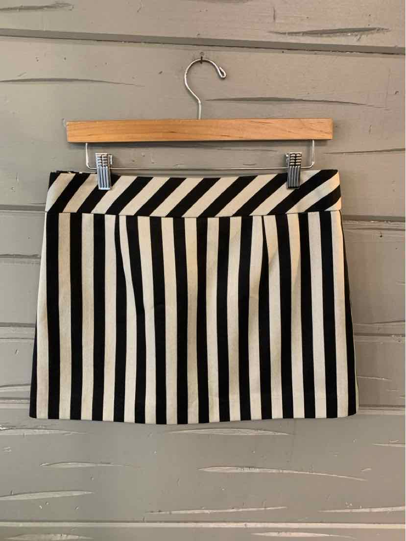 Black and white striped mini skirt with diagonal waistband detail, size 6, hanging on wooden hanger.