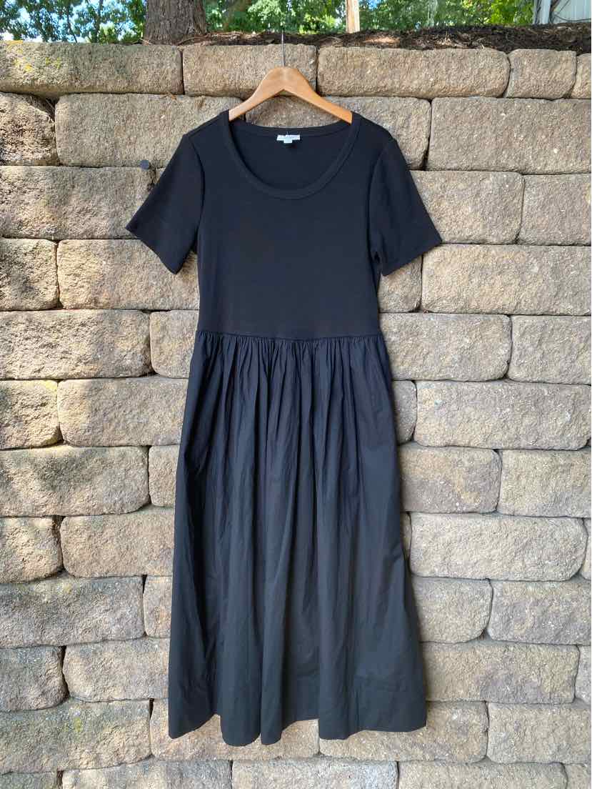 Black short-sleeve dress with fitted bodice and gathered midi-length skirt hanging on wooden hanger.