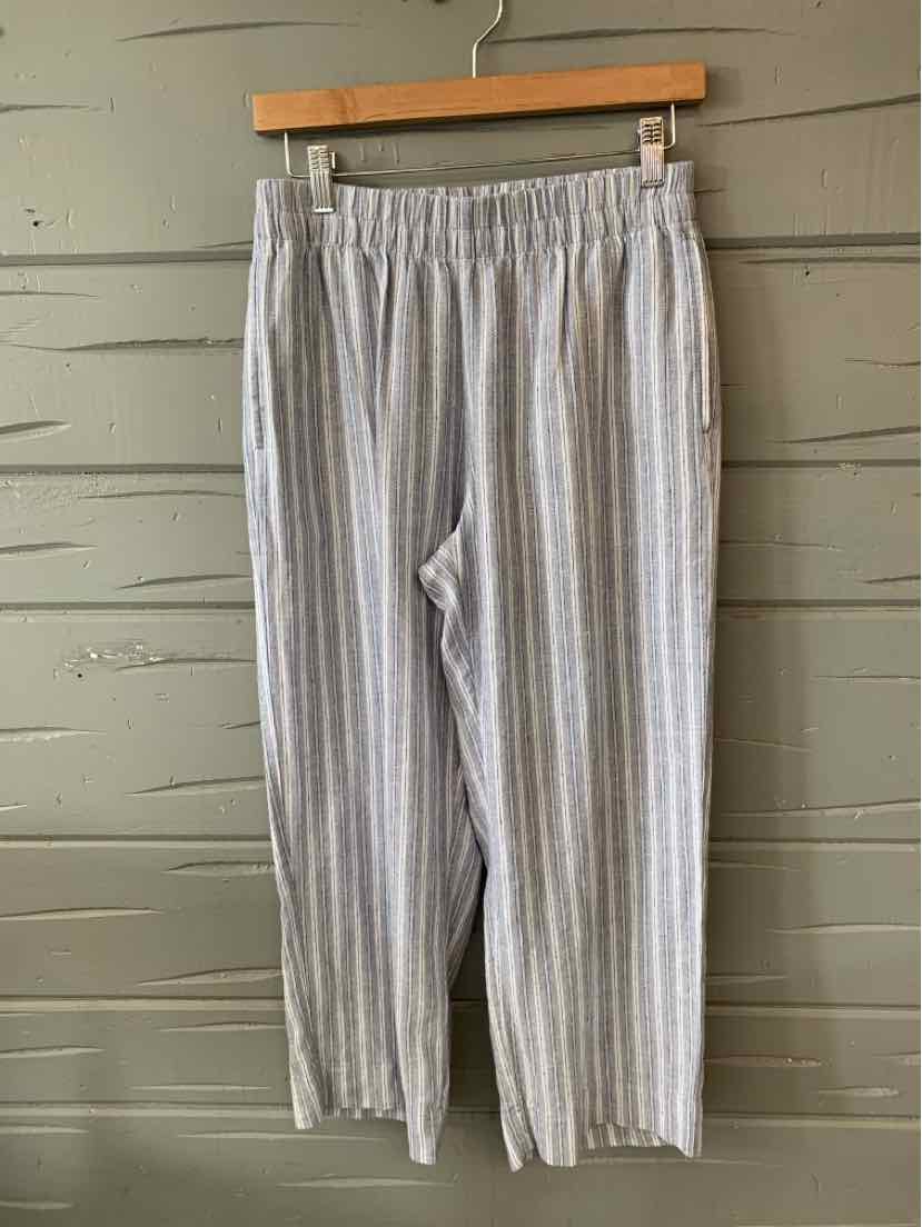 Light gray pants with vertical white and blue stripes and an elastic waistband hanging on a wooden hanger.
