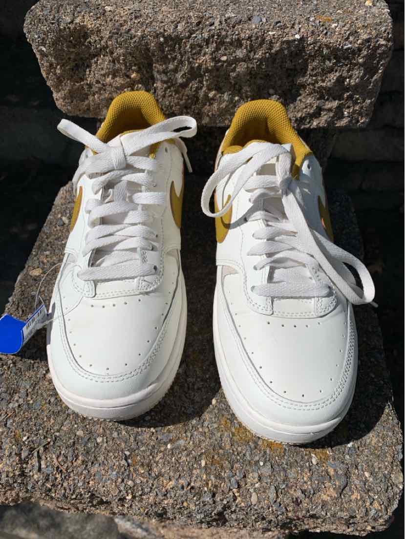 White Nike sneakers with mustard yellow interior and white laces, size 8.