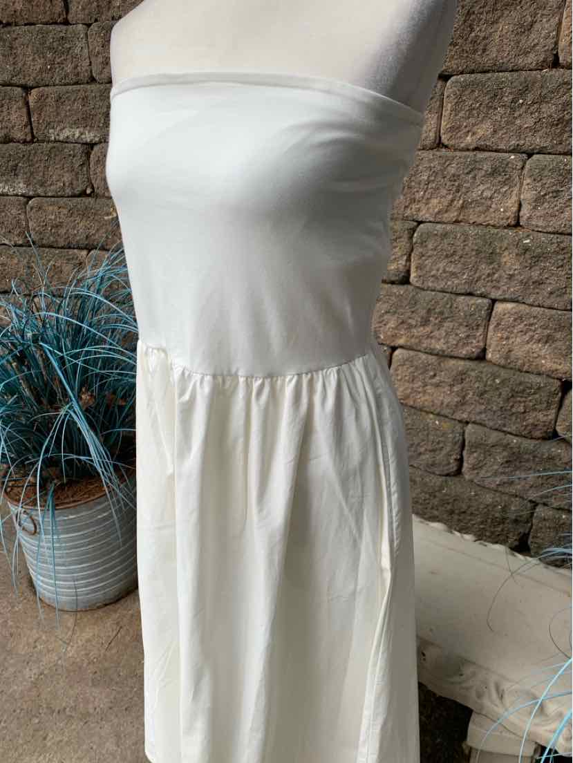 White strapless dress with fitted bodice and gathered skirt, lightweight fabric.
