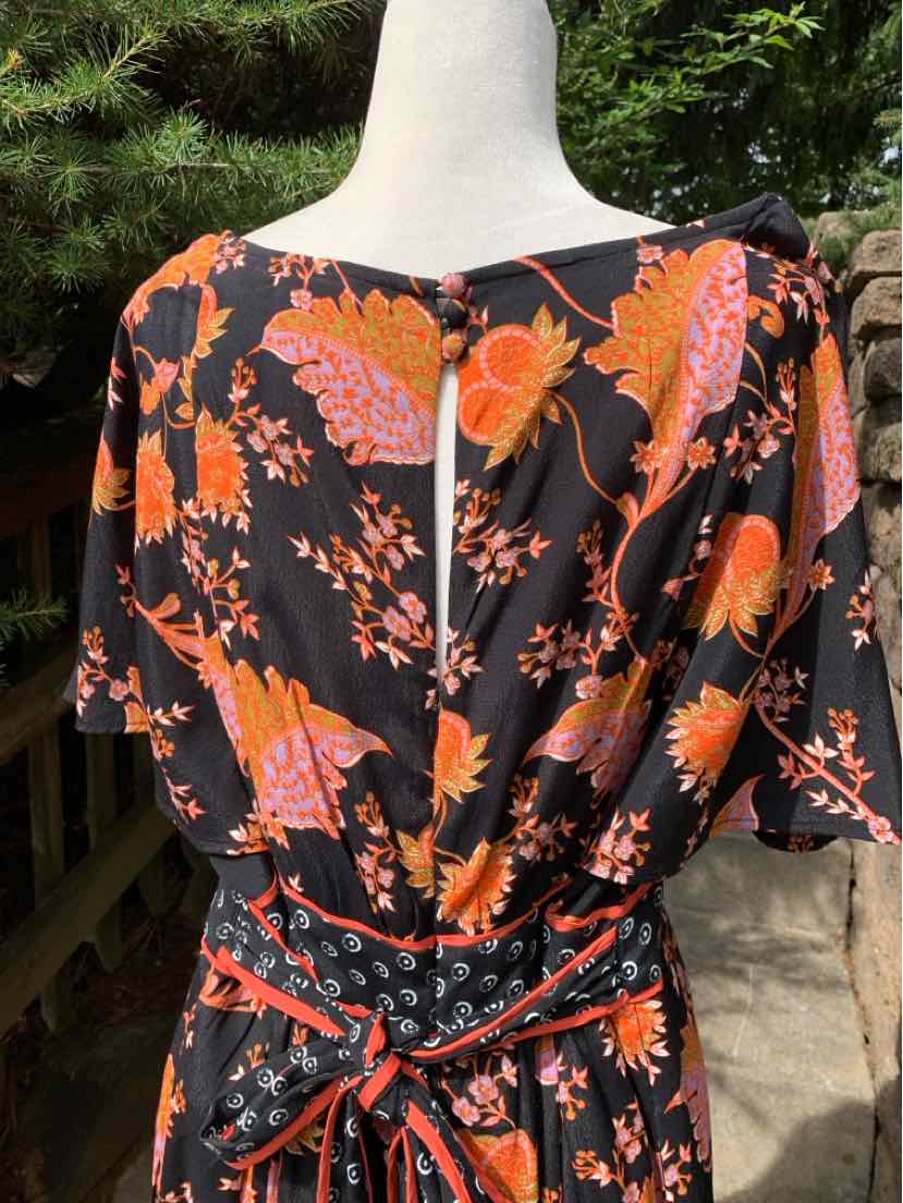 Black dress with vibrant orange and pink floral print, cinched waist with sash tied in a bow, square neckline, and short.