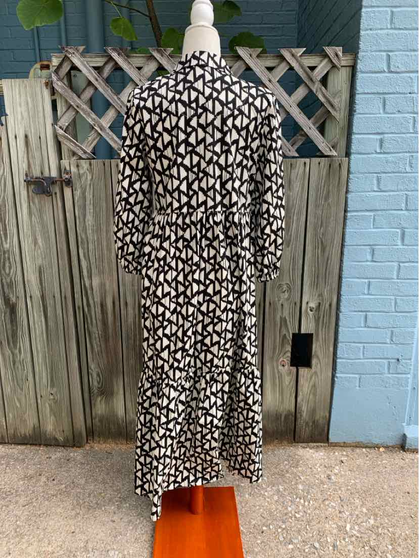 Black and white geometric patterned midi dress with long sleeves and a belted waist.