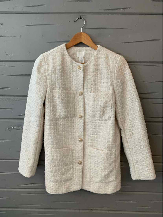 Ivory tweed blazer with a collarless neckline, long sleeves, and front patch pockets.