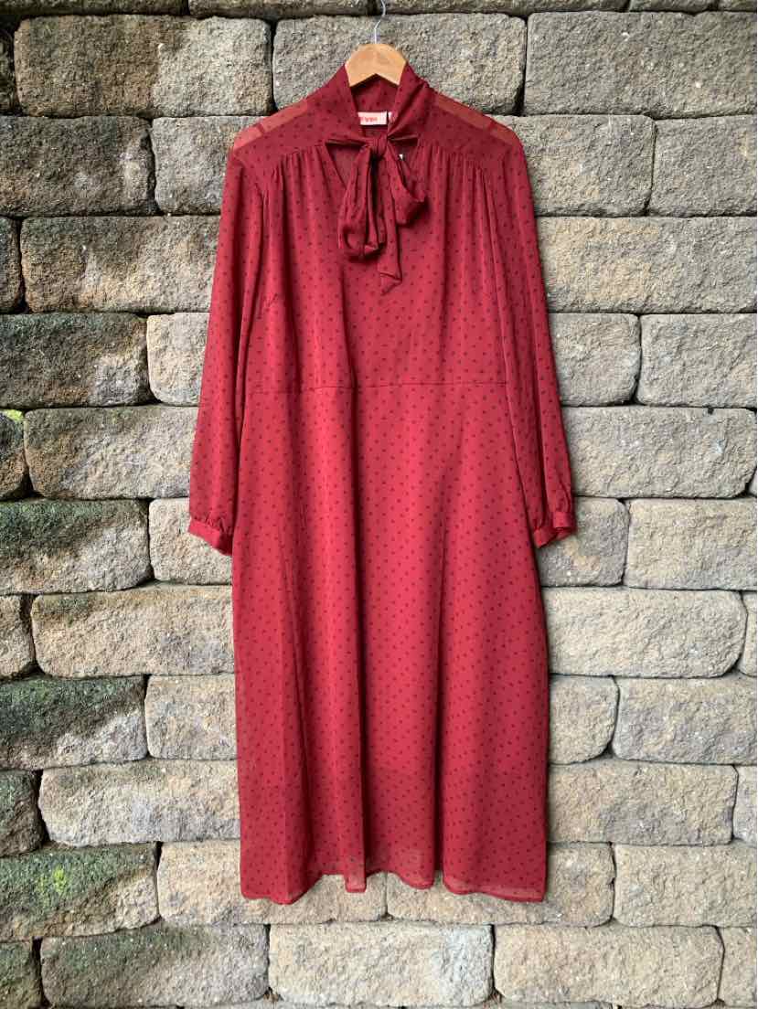 Long-sleeve red midi dress with subtle pattern, high neckline, and bow tie detail.