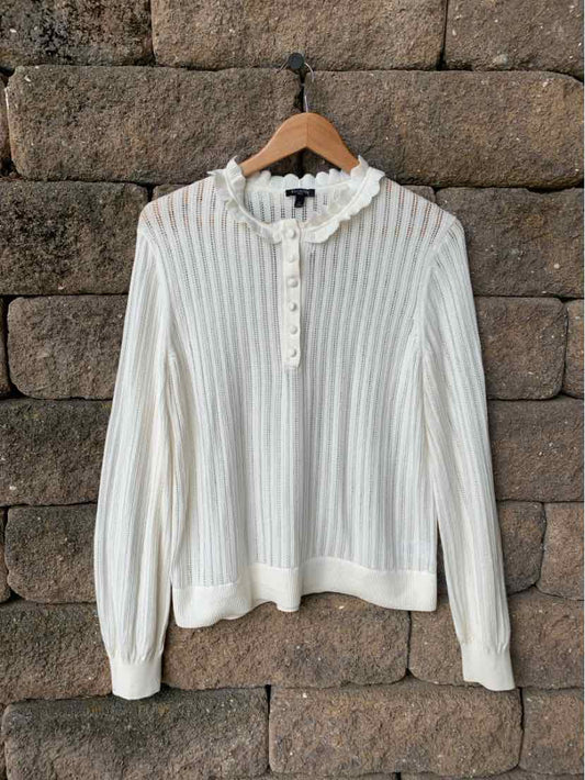 Cream ribbed knit long-sleeve sweater with ruffled collar and button-down front.