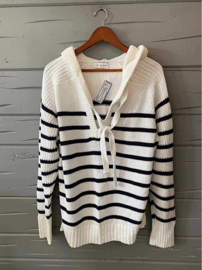 Cream knit cardigan with navy horizontal stripes, button front, and ribbed cuffs and hem, hanging on a wooden hanger.