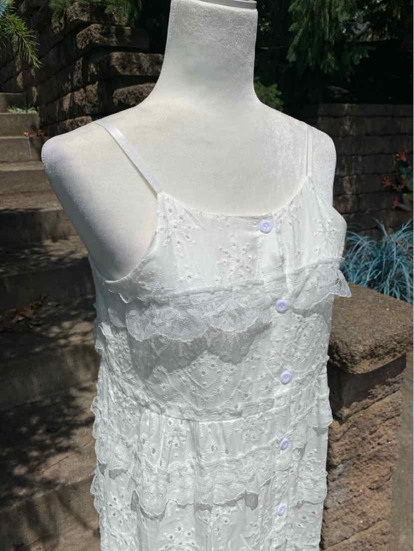 White eyelet eyelet lace dress with thin straps and tiered ruffles, button accents down front.
