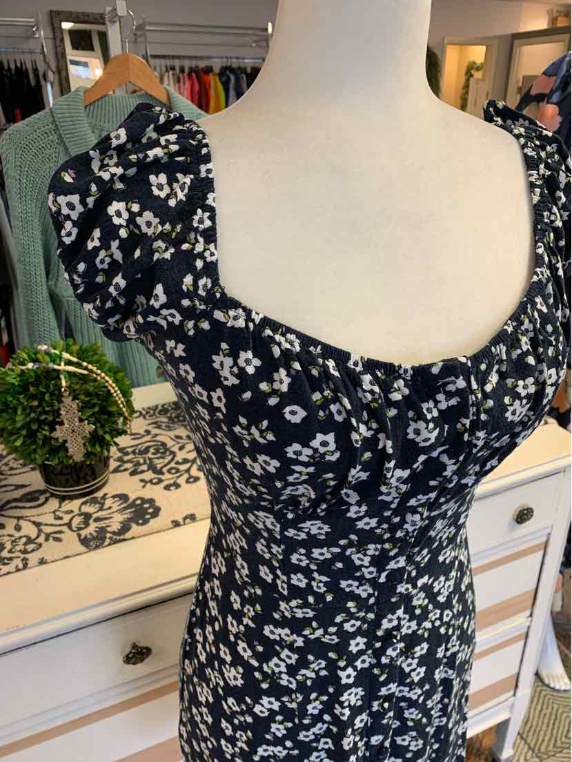 Black floral dress with white flowers, square neckline, puffed short sleeves, and fitted bodice.