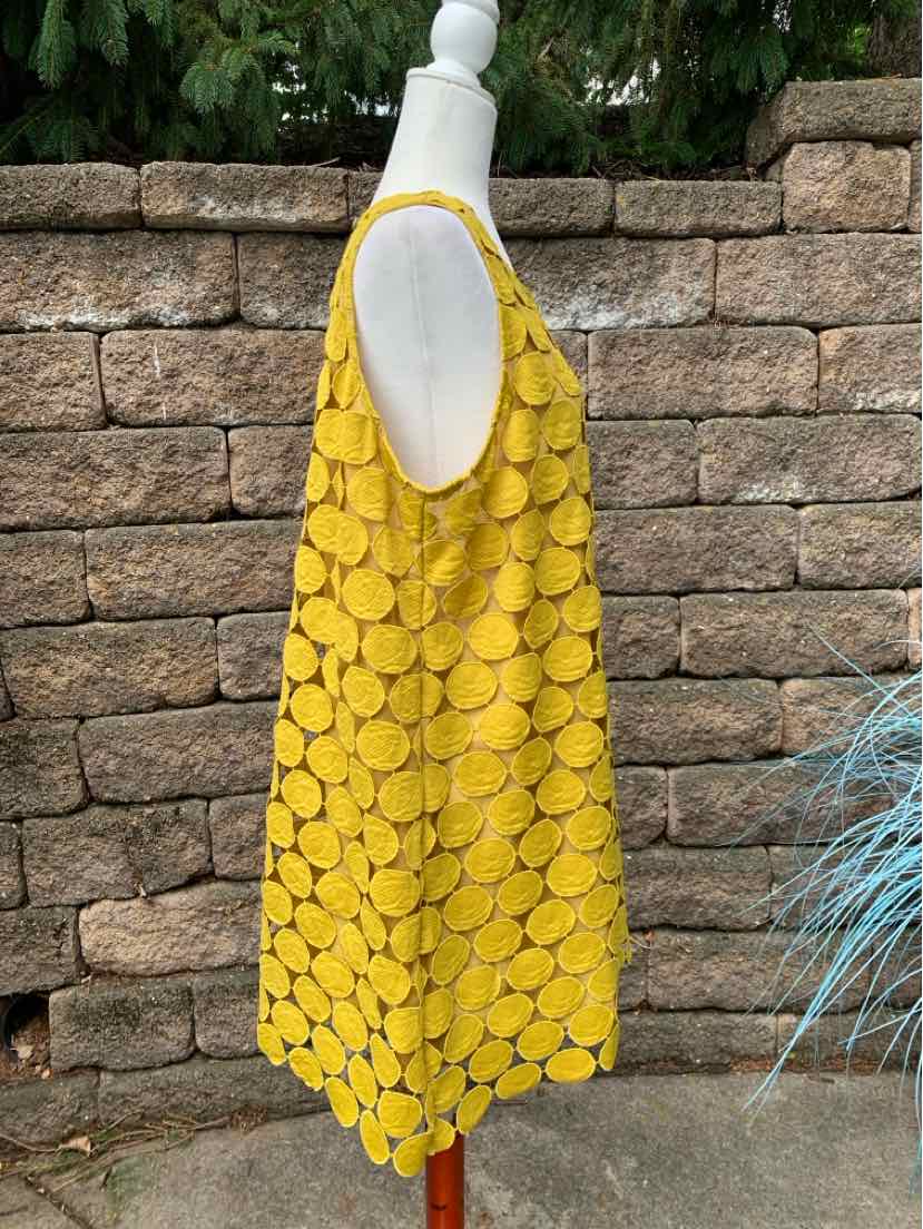 Sleeveless yellow dress with circular textured pattern, loose fit, scoop neckline.