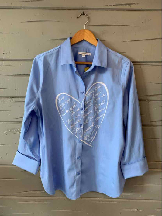 Light blue button-up shirt with long sleeves and a white heart-shaped script design on the front.