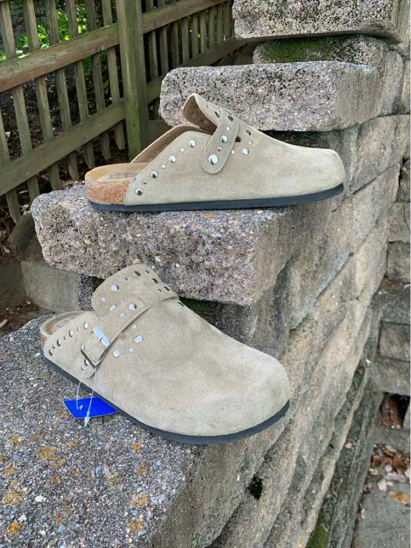 Beige suede low-top shoes with cream laces, silver eyelets, and dark gray soles.