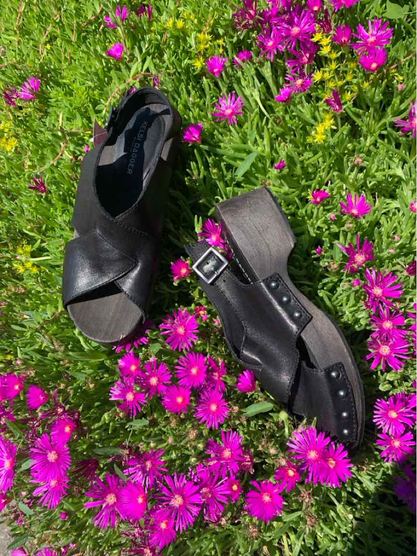 Black leather wedge sandals with crisscross straps and adjustable buckle on heel, size 7.5.