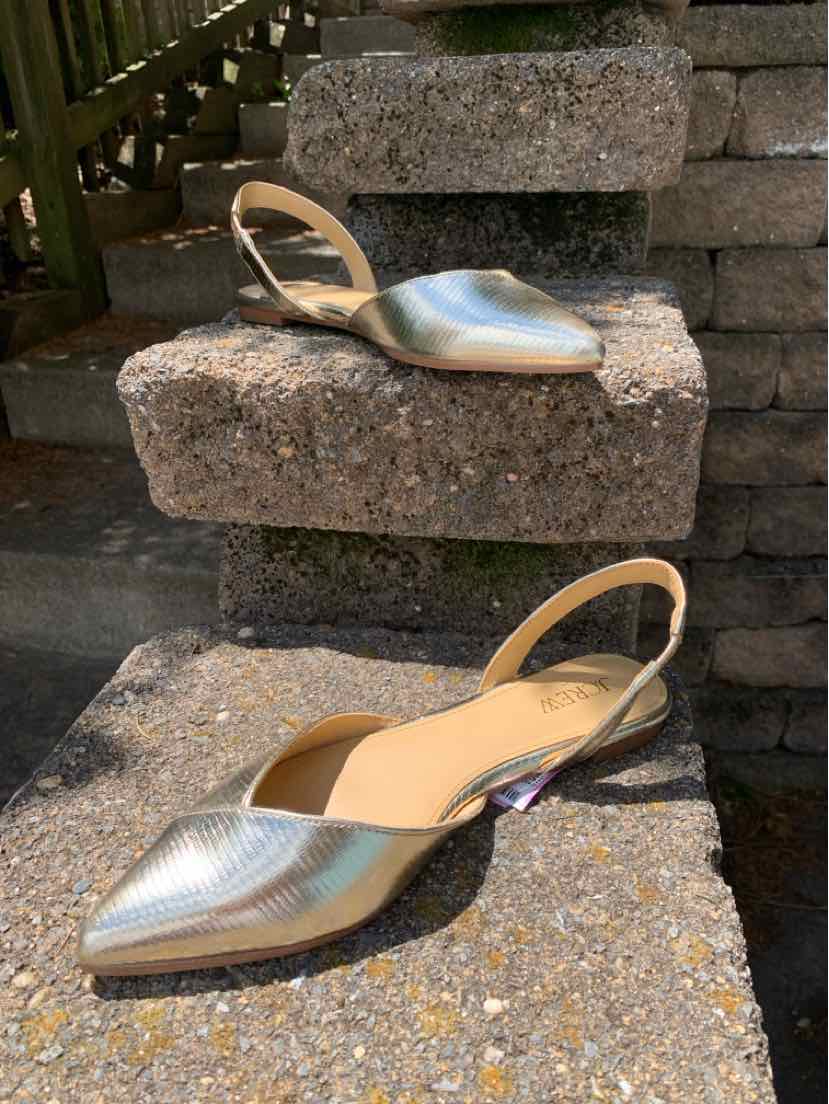 Metallic silver pointed-toe slingback flats with low heel and textured finish.