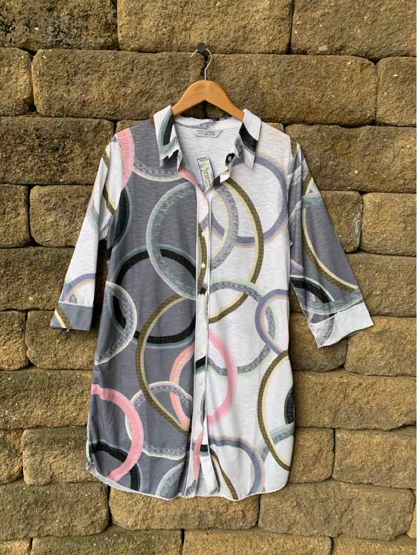 Long button-up shirt with multicolor abstract circle pattern, three-quarter sleeves, collar, and side slits.