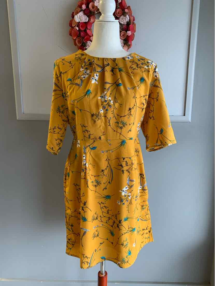 Yellow floral dress with three-quarter sleeves and a gathered neckline on a white mannequin.
