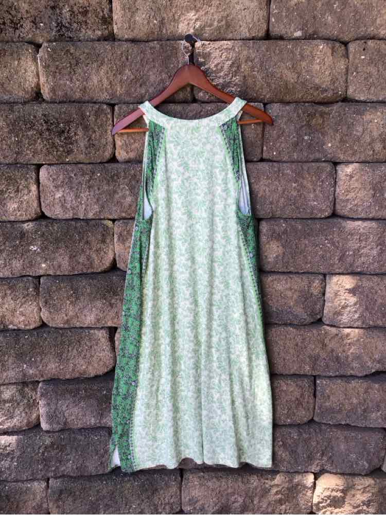 Sleeveless green floral maxi dress with a loose, flowing silhouette on wooden hanger.