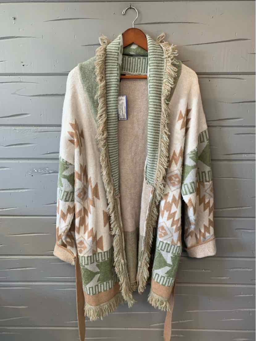 Women’s long cream knit cardigan with sage green trim and a muted geometric pattern, hanging on a wooden hanger.