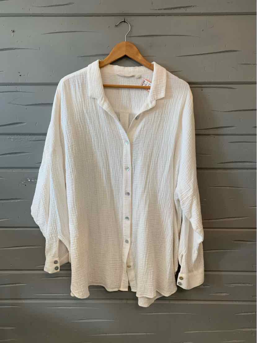 Loose-fitting white button-up blouse with long sleeves and textured fabric.