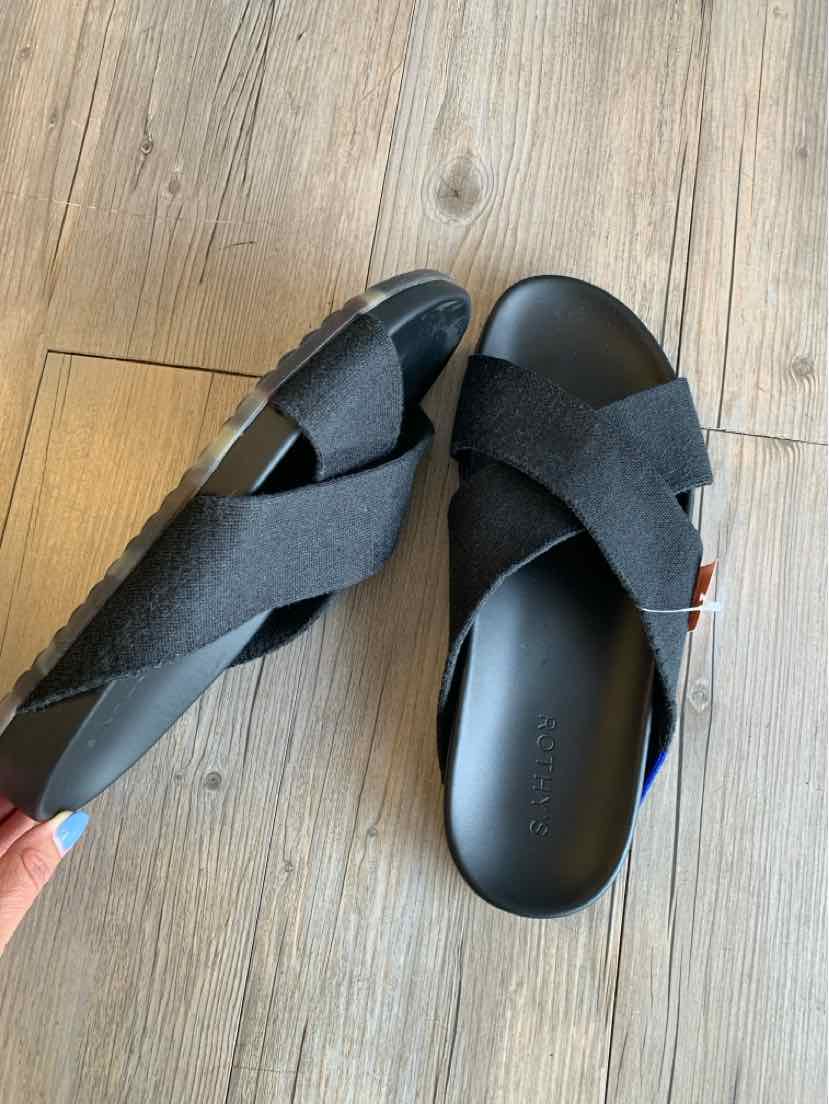 Black slip-on sandals with wide crisscross fabric straps and flat rubber soles, size 9.5.