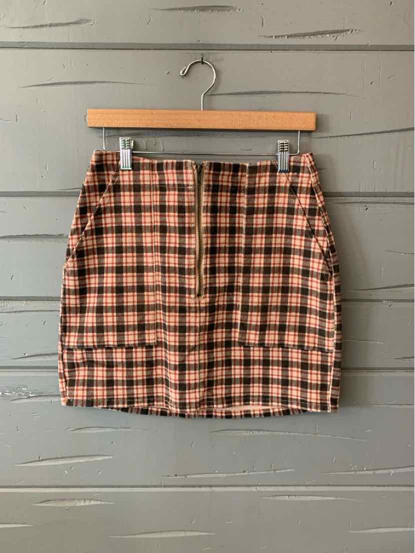 High-waist mini skirt with red and black plaid pattern, front zipper, and fitted silhouette.