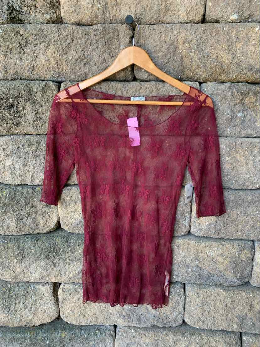 Burgundy long-sleeve ribbed knit top with off-shoulder straps and a fitted silhouette hanging on wooden hanger.