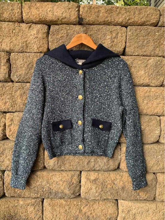 Gray knit cardigan with navy collar, gold buttons, and navy-trimmed front pockets.