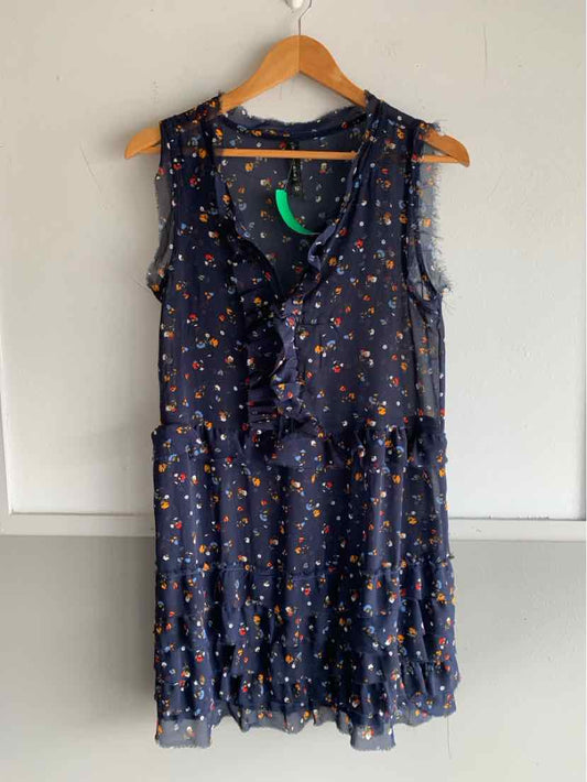 Sleeveless navy blue dress with small multicolor floral print and ruffle details on front and hem.