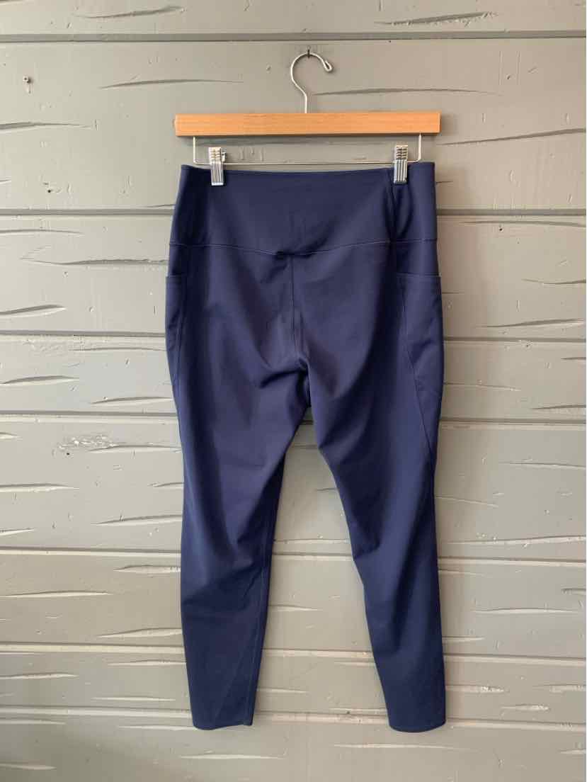 Navy blue high-waisted leggings with a smooth, stretchy fabric and a fitted silhouette hanging on a wooden hanger.