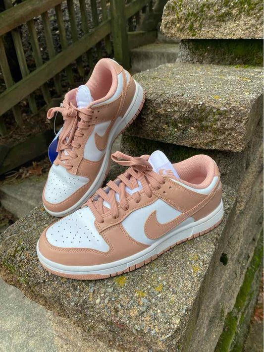 White and light brown Nike sneakers with perforated toe box and white swoosh, size 8.5.