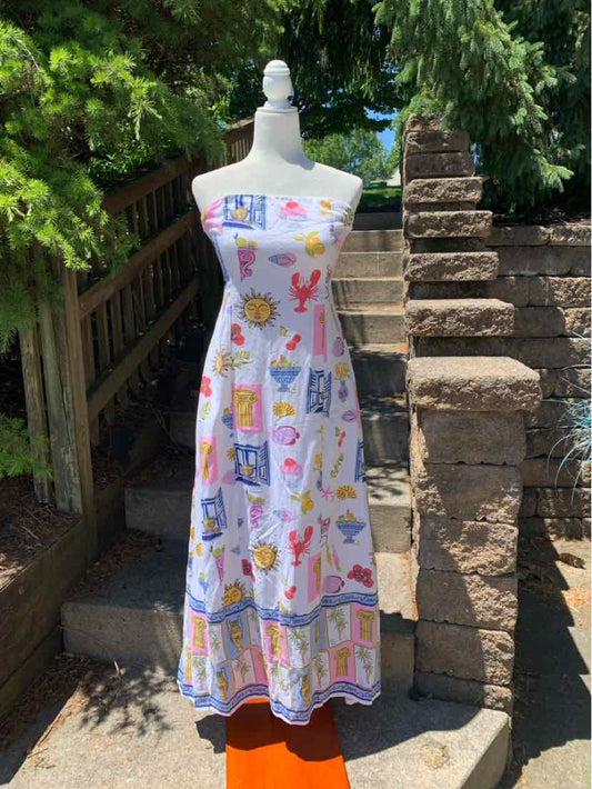 White sleeveless maxi dress with colorful butterfly and flower print, fitted bodice, flared skirt.