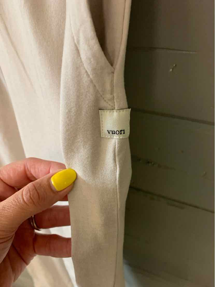 Off-white soft fabric tank top with VUORI logo tag on side seam, size XS.
