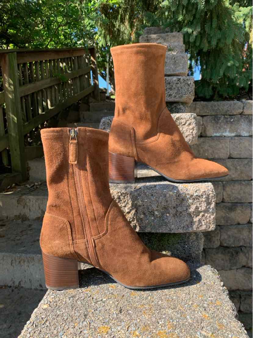 Pair of cognac-brown suede knee-high boots with rounded toes, side zippers, and low block heels.