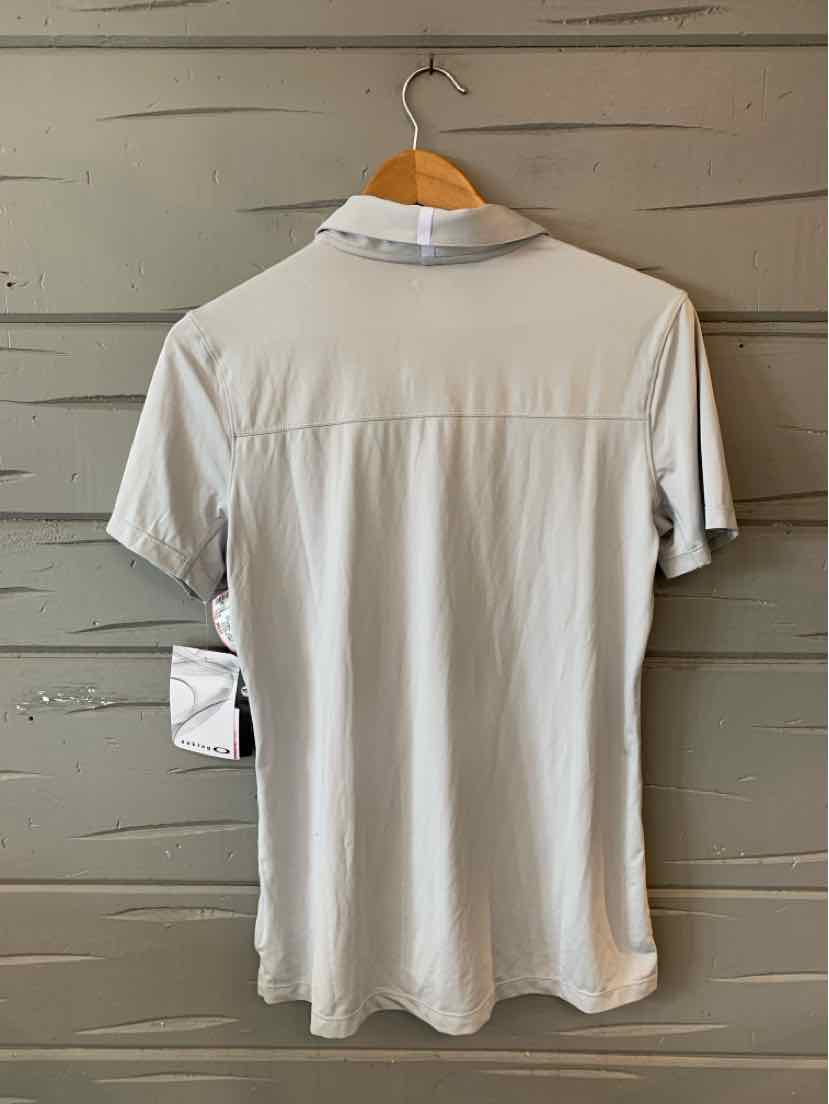 Light gray short-sleeve polo shirt with a white collar and small button placket hanging on wooden hanger.