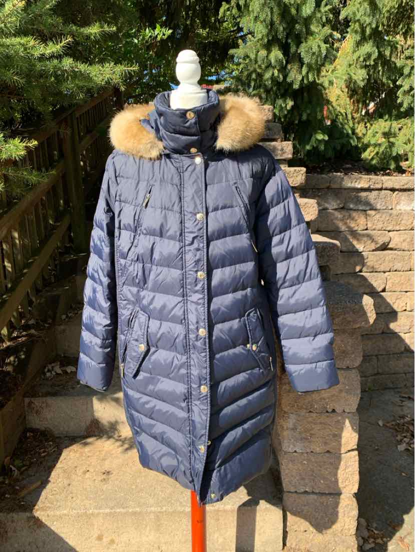 Women's navy blue quilted puffer coat with a longline shape, tan fur-trimmed hood, and gold-tone buttons.