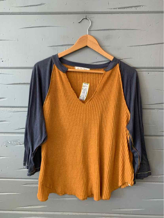 Orange waffle knit top with black raglan sleeves and a scoop neckline, size small.