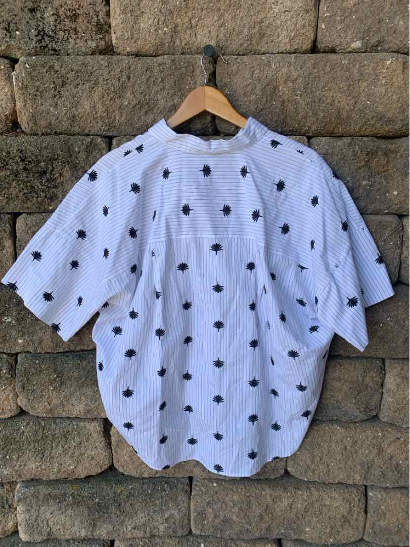 White short-sleeve blouse with black polka dots, loose fit, and gathered neckline.