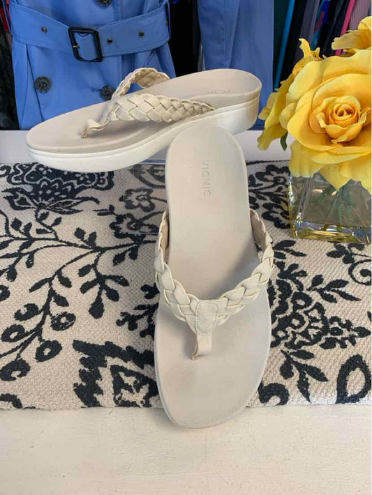 Tan braided strap sandal with contoured footbed and cushioned sole, size 9.