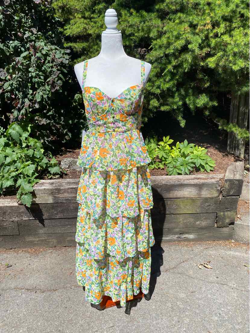 Floral tiered maxi dress with multicolored flowers on light fabric and spaghetti straps.