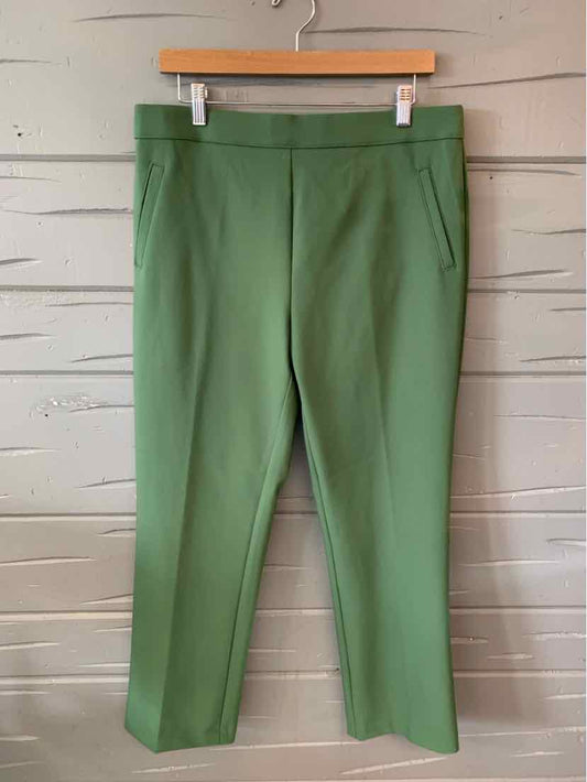 Green tailored trousers with straight legs and side pockets hanging on wooden hanger.