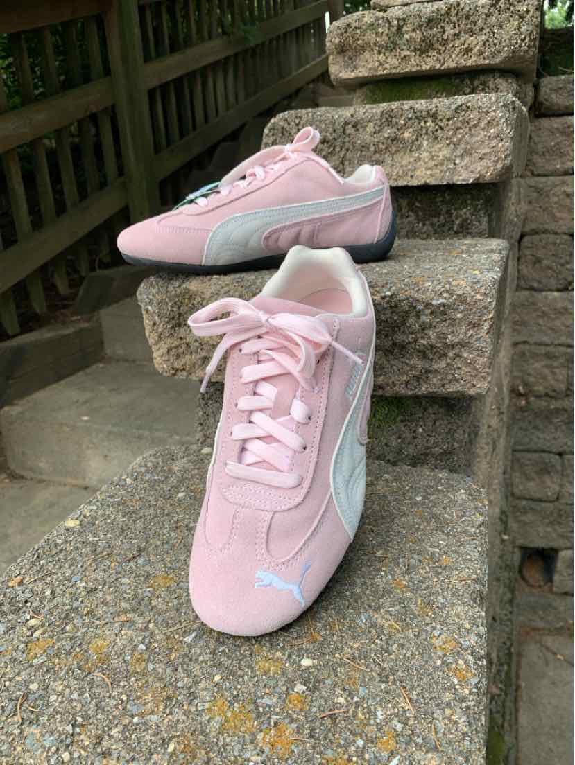 Pink suede Puma sneaker with white side stripe, lace-up front, and size 6.5 label.