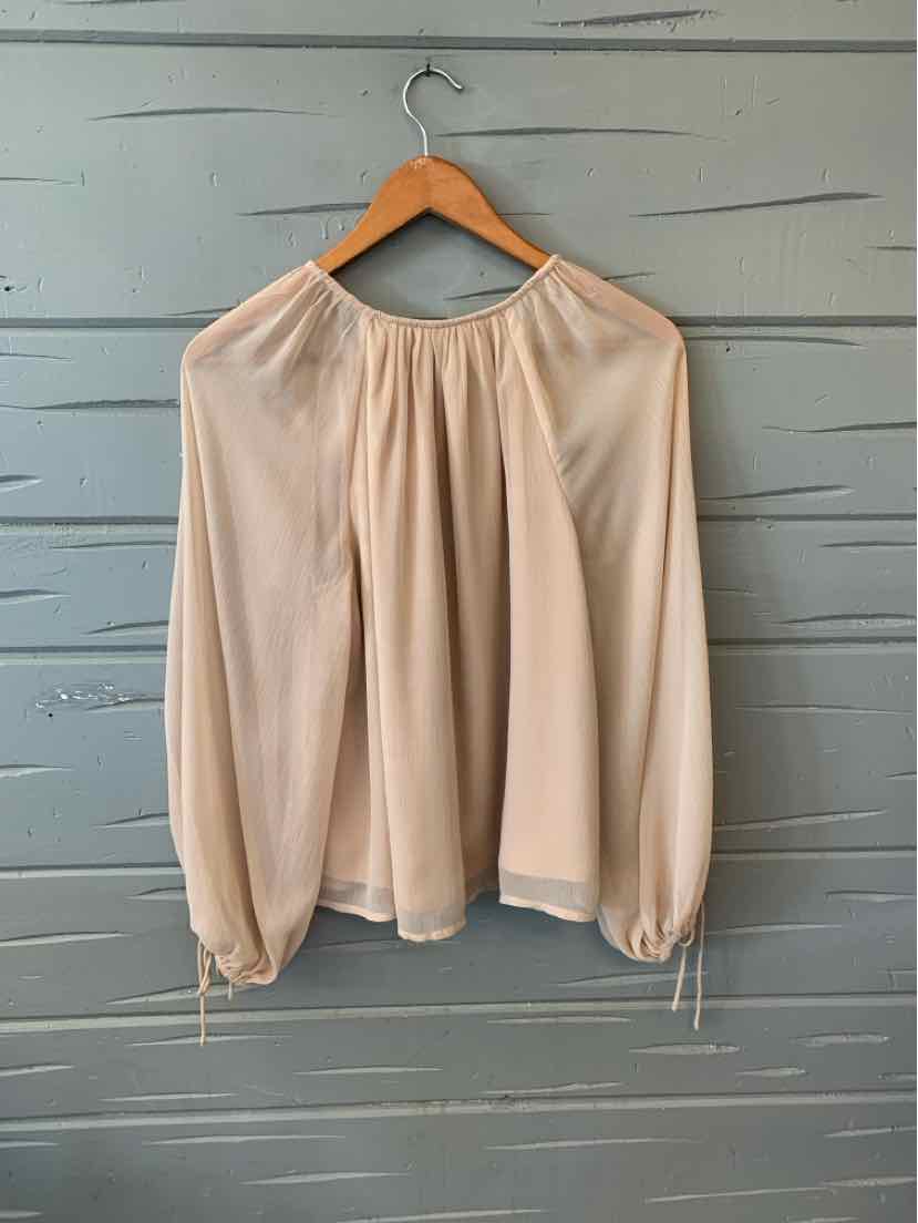 Light beige long-sleeve blouse with gathered neckline and cinched cuffs on wooden hanger.