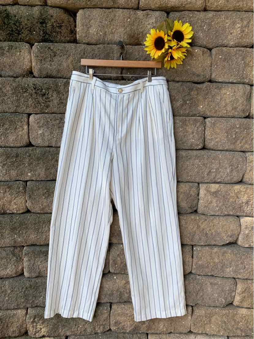 White wide-leg pants with vertical thin blue and beige stripes and a button closure waistband hanging on wooden hanger.