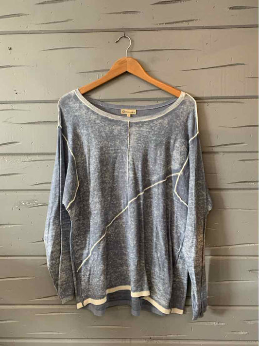 Light blue long-sleeve sweater with white trim and subtle diagonal stitch detail, relaxed fit.