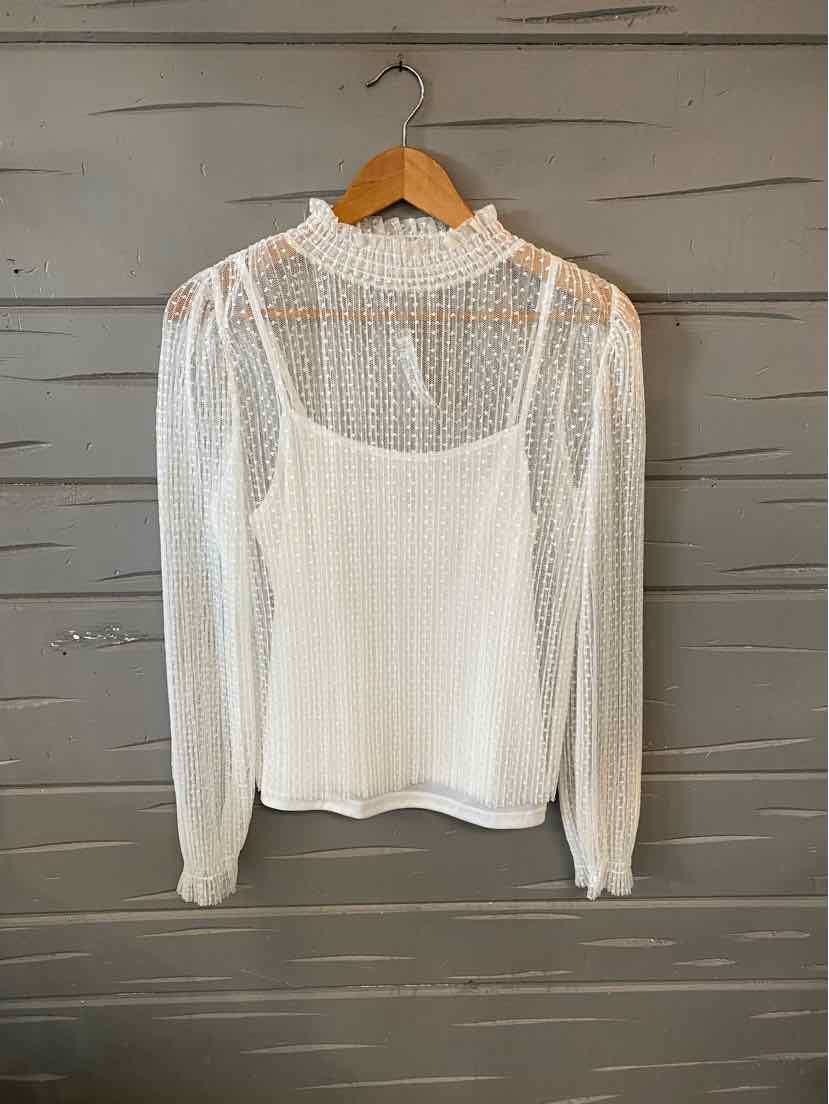 White lace long-sleeve blouse with sheer puff shoulders and high neckline on wooden hanger.